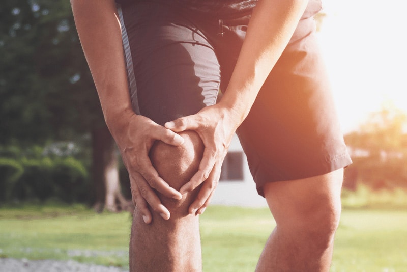 Person holding a painful knee